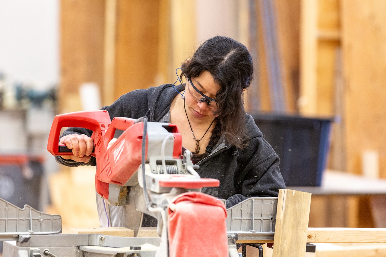 carpentry student elaine kennedy using a miter saw