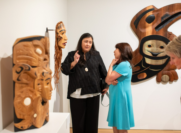 Arlene Ness speaks to an exhibition attendee at the opening.