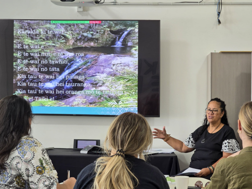 Students listening to a host share Māori culture and traditional child rearing practices