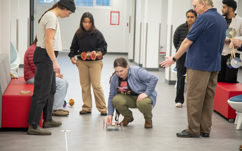 Students test out mousetrap powered vehicles in the hallways